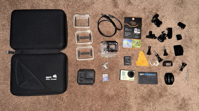 Action camera bundle with open hard case, camera, batteries, mounts, and accessories