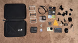 Action camera bundle with open hard case, camera, batteries, mounts, and accessories