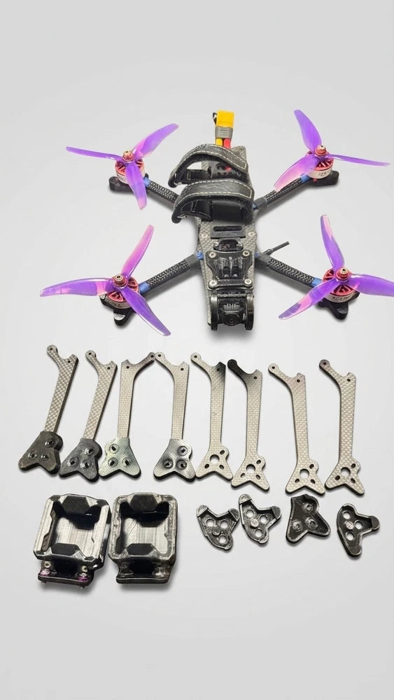 Purple-prop FPV freestyle quadcopter with motor mounts and frame parts, assembled and extras