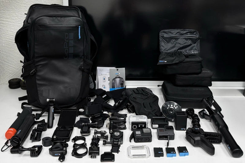 Black action camera accessory kit with multiple mounts, cases, and camera housings