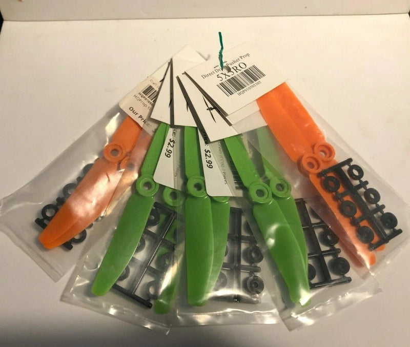 Green and orange drone quad rotor blade set in sealed plastic packaging