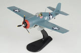 Gray-blue WWII fighter plane model with propeller and star insignia on black display stand