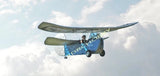 Olive green RC biplane model flying with visible propeller and wings