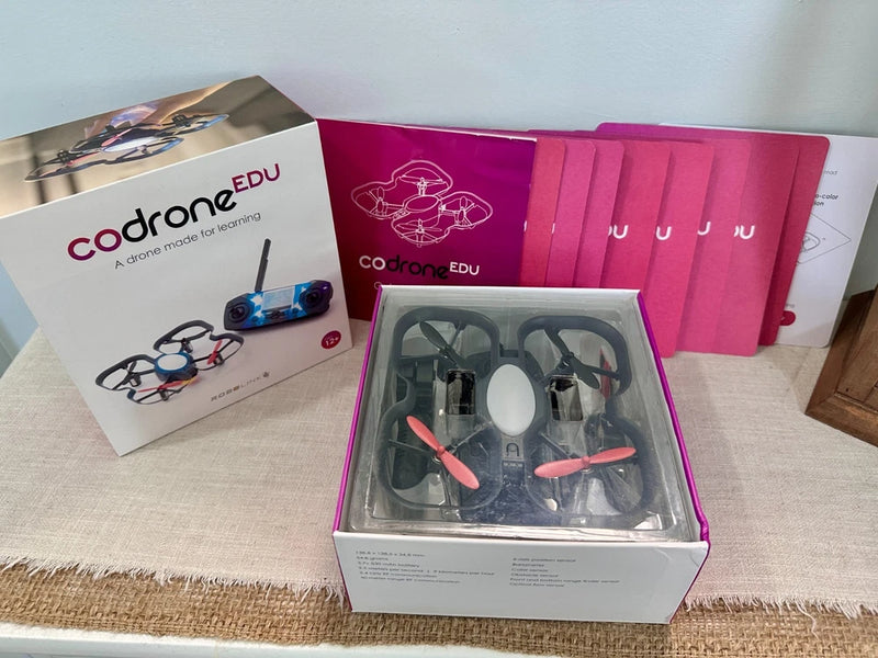 Programmable drone learning kit, open box with quadcopter and propellers