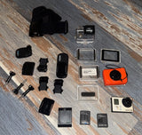 Action camera kit with black camera, protective housing, mounts, battery and frames