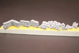 Unpainted resin model kit sandbag corner armor pieces on base, light gray
