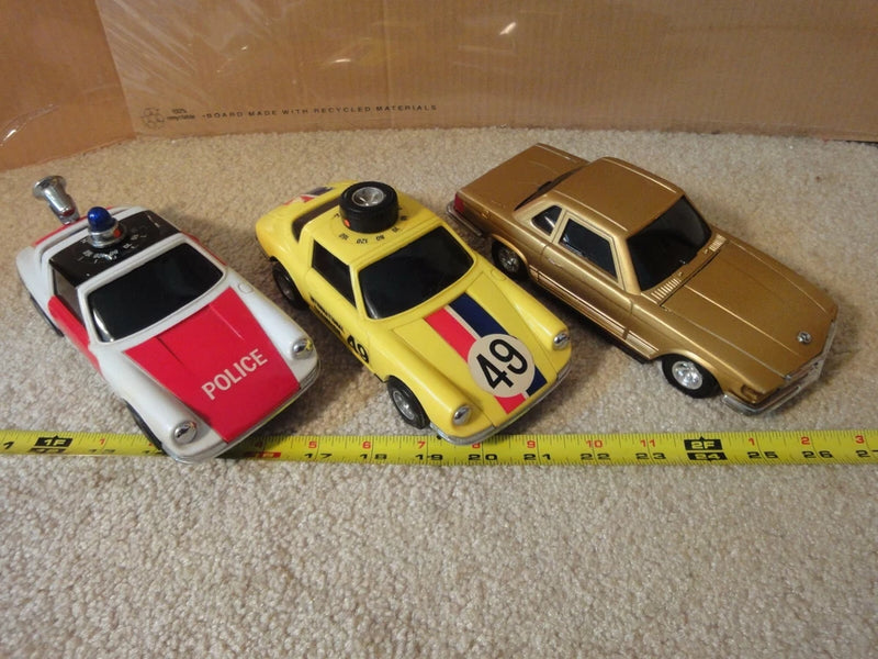 Vintage battery-operated police model car radios, three die-cast style vehicles