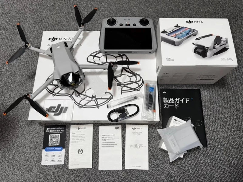 Gray quadcopter drone kit with controller, manuals, and cables