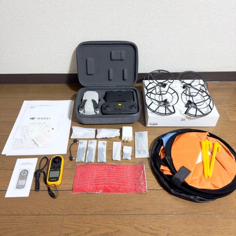 Drone accessory kit in hard case with orange landing pad, spare parts, propellers