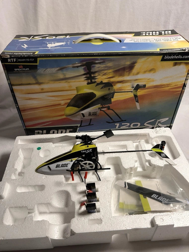Blade 120 SR RC helicopter kit in foam tray with blades and parts, yellow and black.