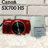Red Canon PowerShot SX700 HS digital camera with battery charger and battery pack