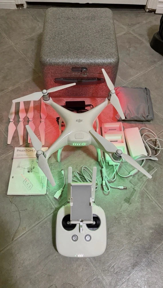 White DJI Phantom 4 drone with remote controller and accessories, ready to fly