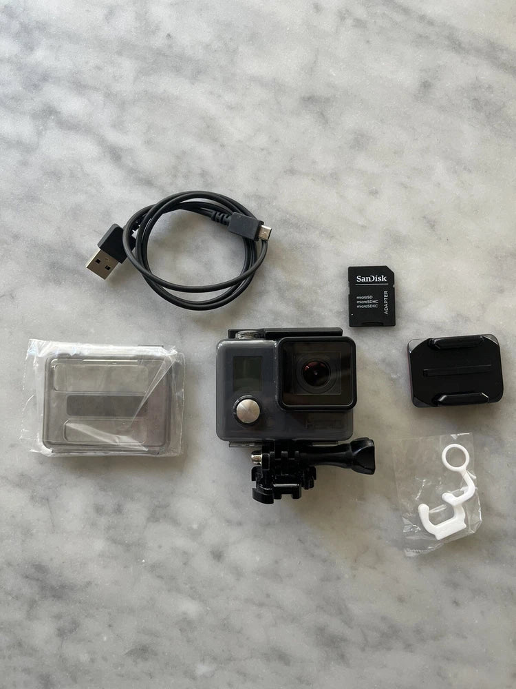 Grey GoPro HERO action camera with waterproof case, mount, USB cable, and SanDisk card