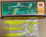 Lime-green plastic miniature plane kit parts: fuselage, wings, and bagged pieces