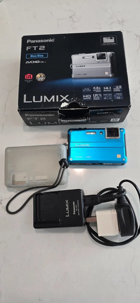 Blue Panasonic Lumix FT2 compact camera with charger, cables, and battery pack