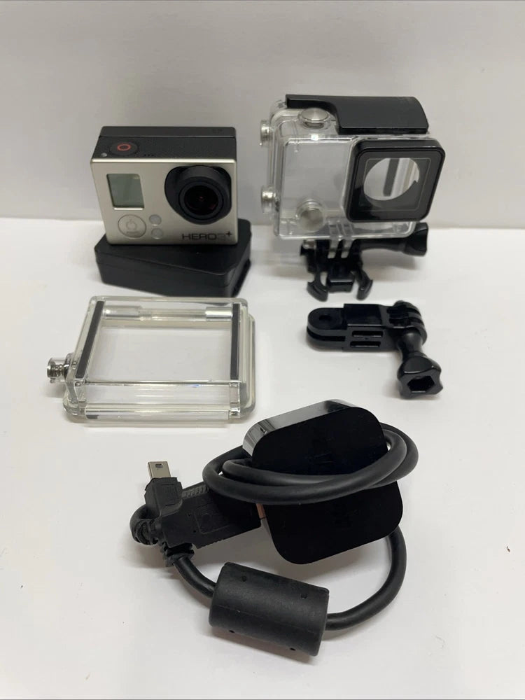 Action camera with clear waterproof housing, mount base, and charging cable