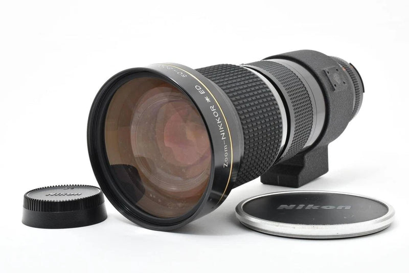 Black telephoto zoom camera lens with front glass and rear cap, Nikon F mount