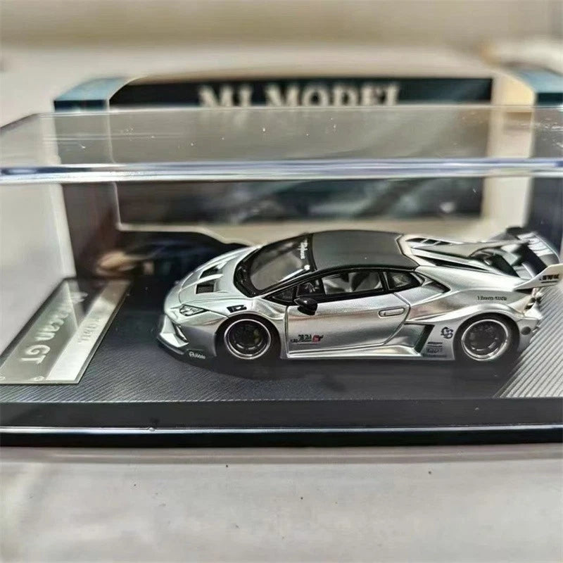 Silver and black die-cast sports car model in display case, 3/4 front view, detailed wheels