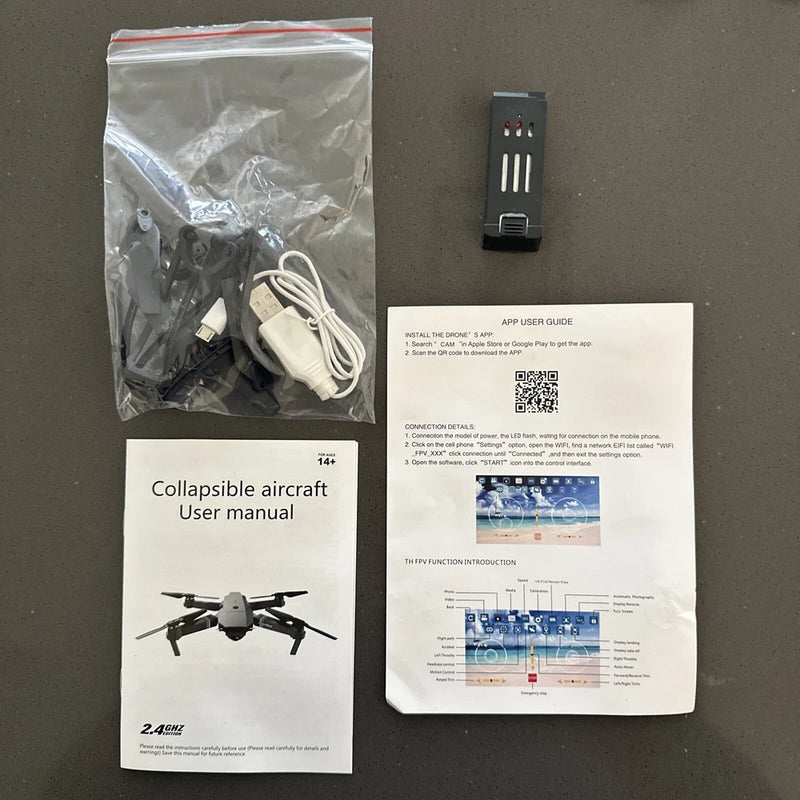 Collapsible RC drone user manual, app guide, and white charging cable set