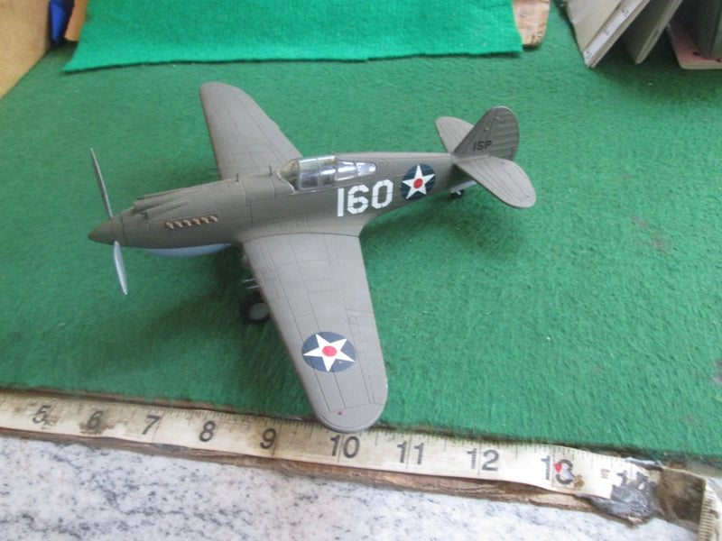 Grey WWII-style airplane model with propeller and US wing star markings, front-left view