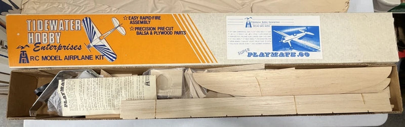 RC aerobatic airplane model kit with balsa wood fuselage parts, open box