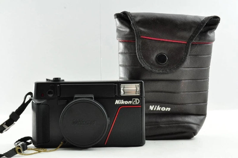 Nikon compact camera with lens cap and black carrying case