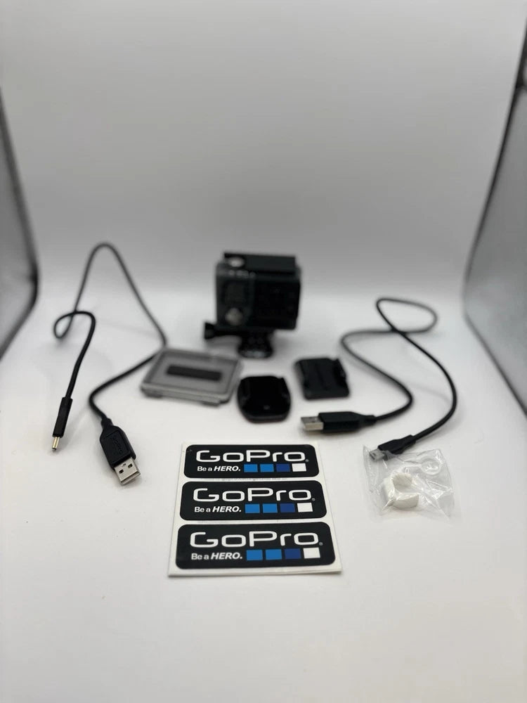GoPro action camera with LCD screen, accessories, cables, and two GoPro cards