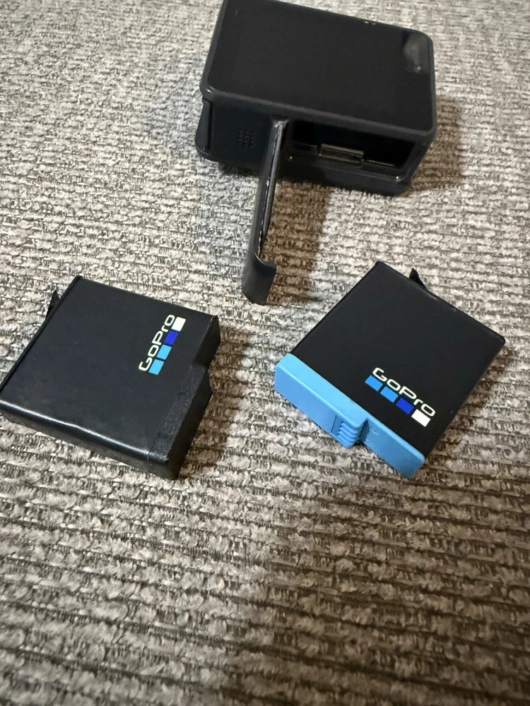 Black GoPro HERO7 action camera with blue battery door and protective case pieces