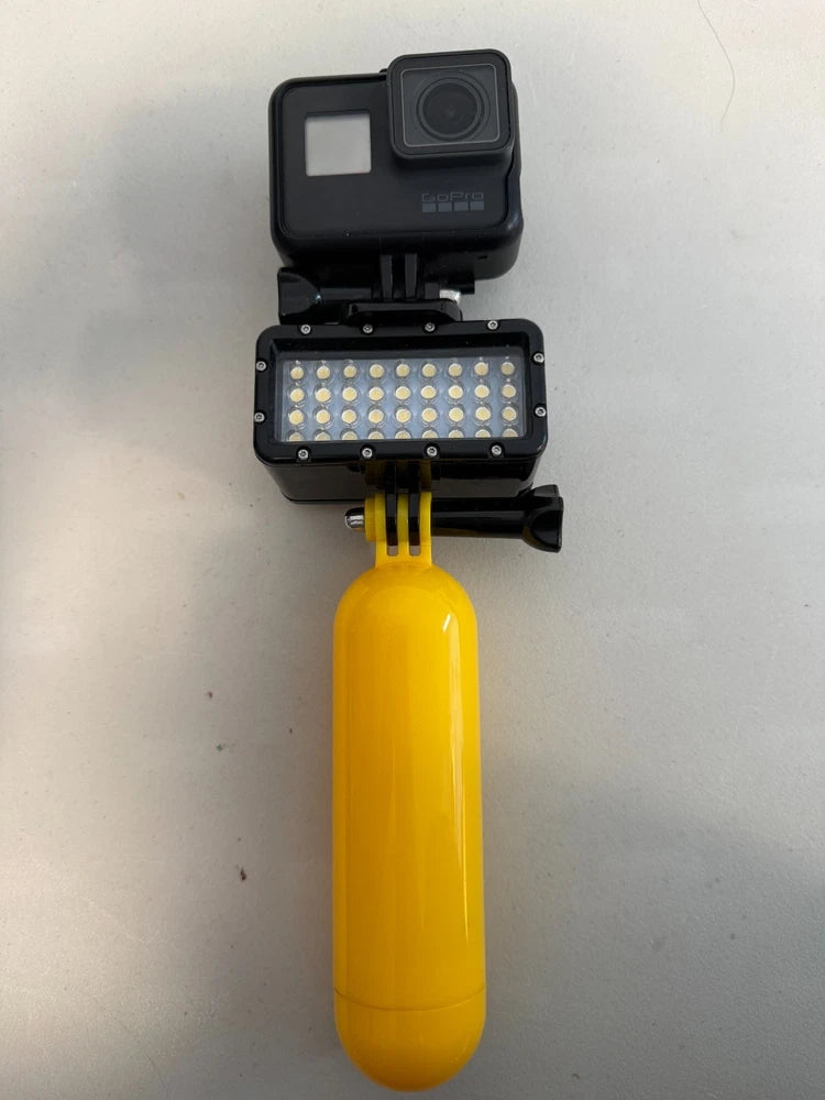 GoPro action camera with open housing and yellow LED light attachment