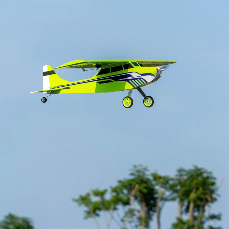 RC balsa wood airplane, green and yellow fuselage, propeller and tricycle landing gear