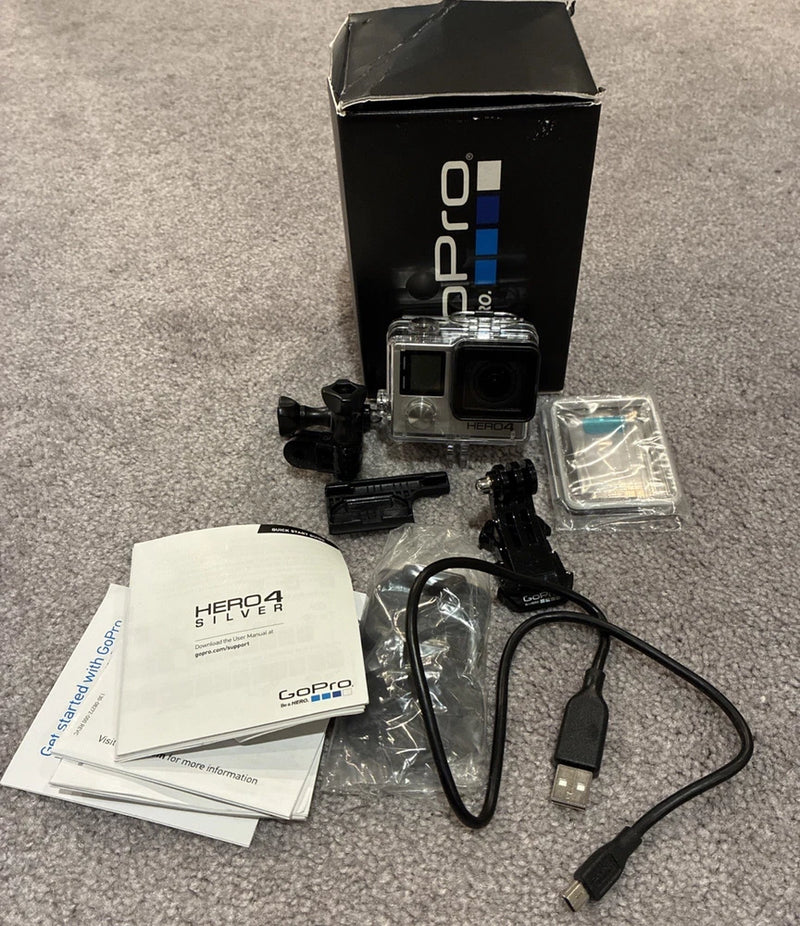 GoPro HERO4 Silver action camera with housing, mounts, USB cable, and user manuals