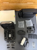 White quadcopter drone accessories set with controller, batteries, cables, and case