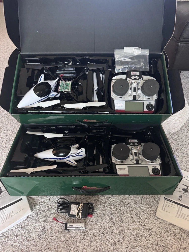 Quadcopter drone set in open box with two controllers and spare parts