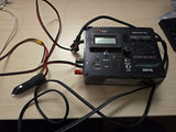 ProTek 706 digital battery charger with LCD screen, controls, and connected power cables