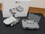 Foldable drone and remote controller with batteries, gray and white