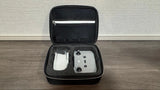 Compact quadcopter drone in open hard carrying case with spare batteries