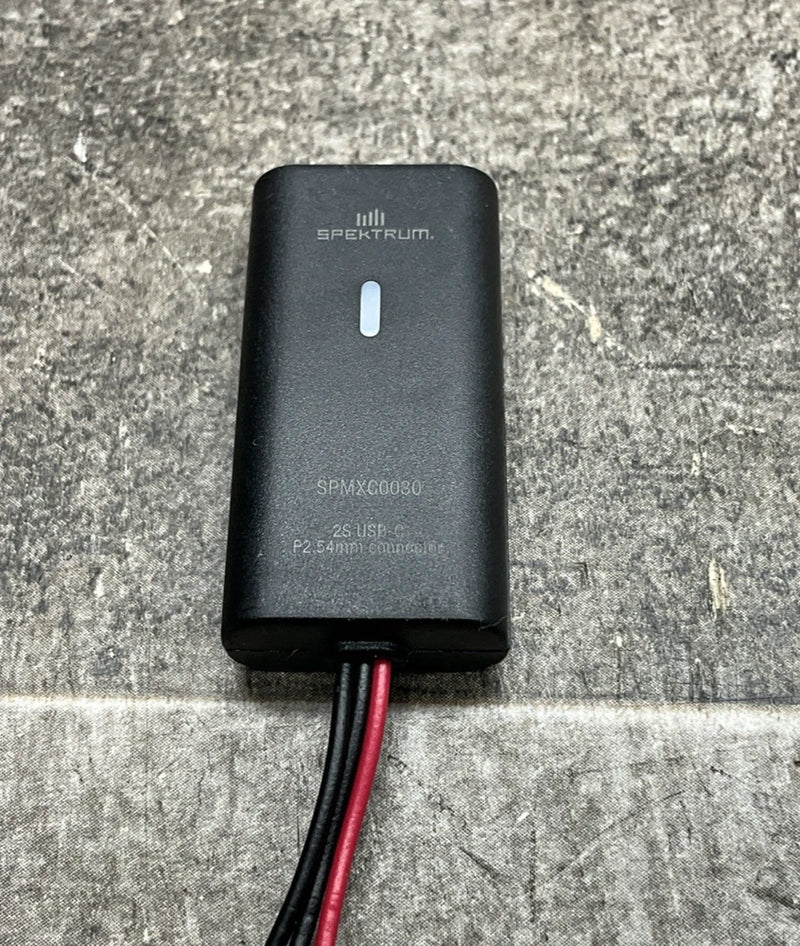 Black LiPo charger with red and black leads, compact rectangular 3-pin body