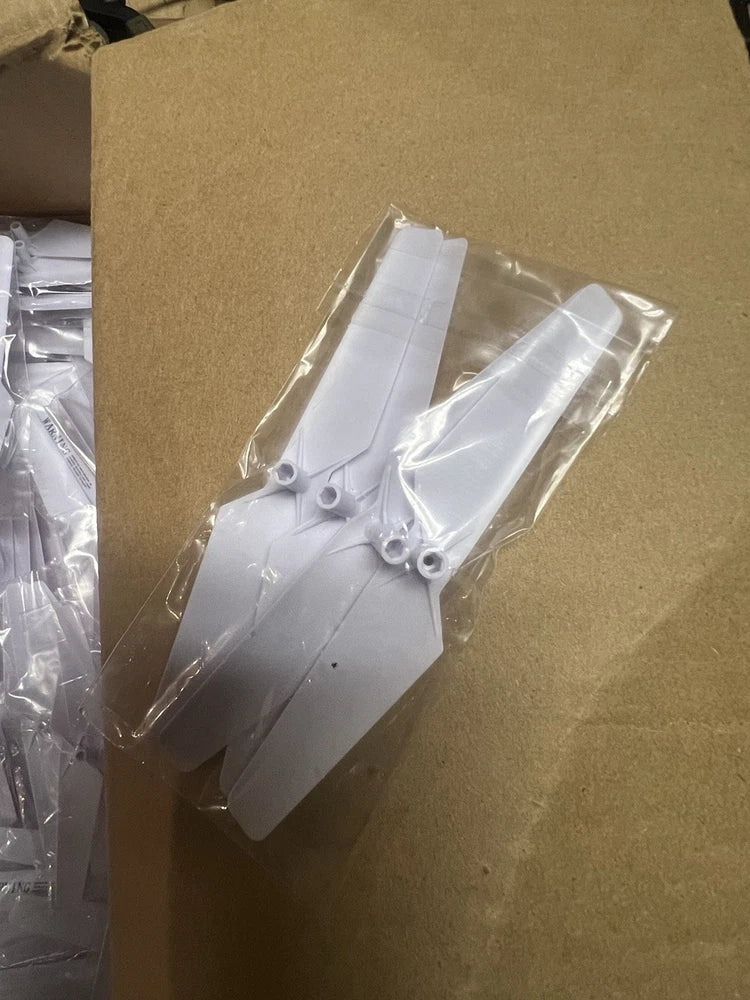 Set of white drone replacement propeller blades in clear packaging