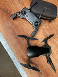 Foldable quadcopter drone with four propellers and black storage case