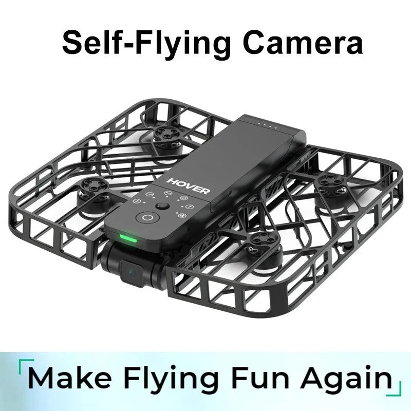 Black self-flying camera drone with four rotors and green status light