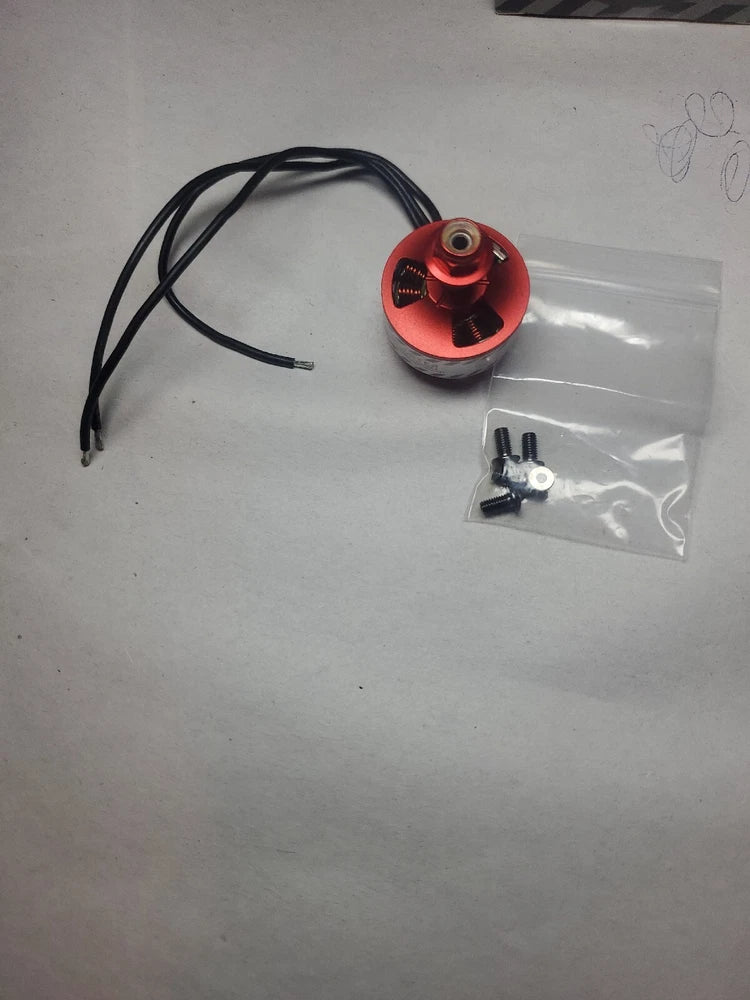 Red brushless RC motor with black wire leads and mounting hardware, in small bag