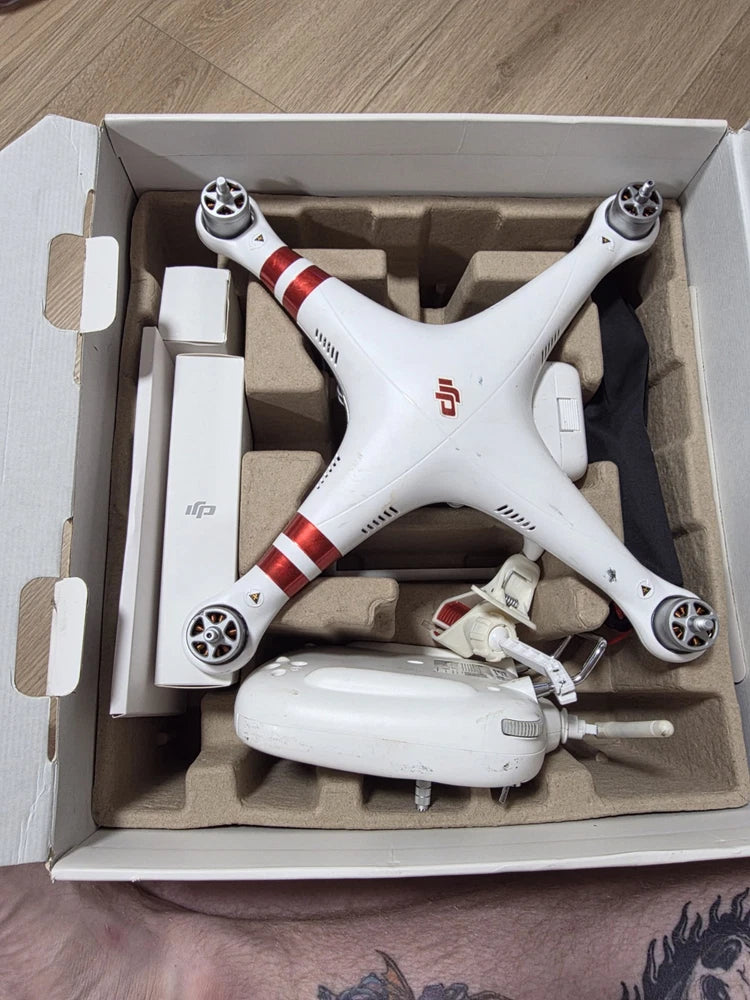 DJI Phantom 3 quadcopter drone in open box with controller and prop guards