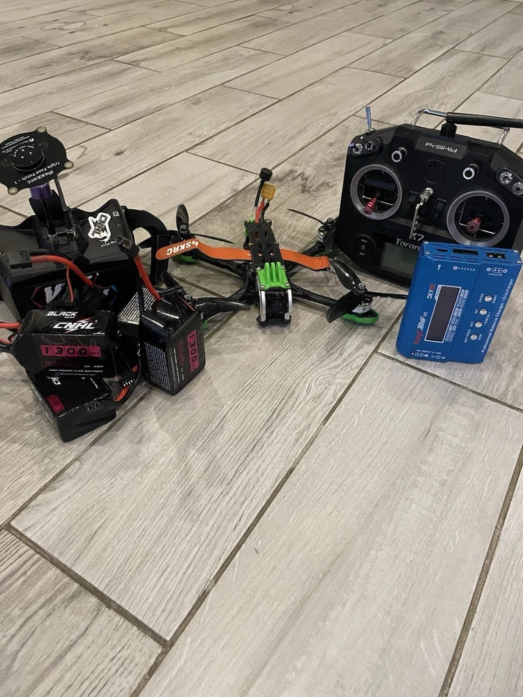 FPV drone kit with transmitter controller, drone components, and blue control box