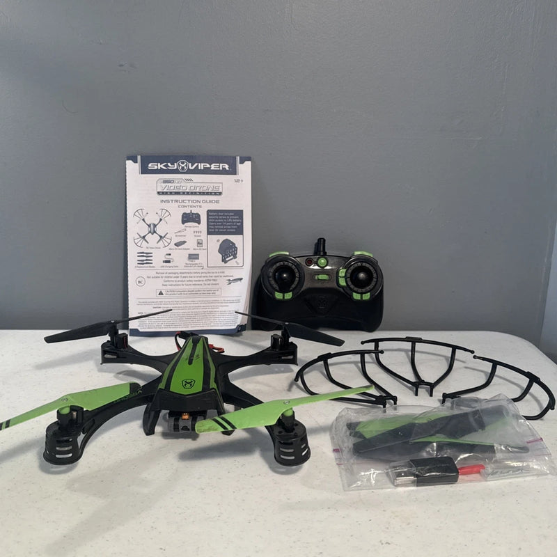SkyViper black and green video stunt drone with controller, spare props, and manual
