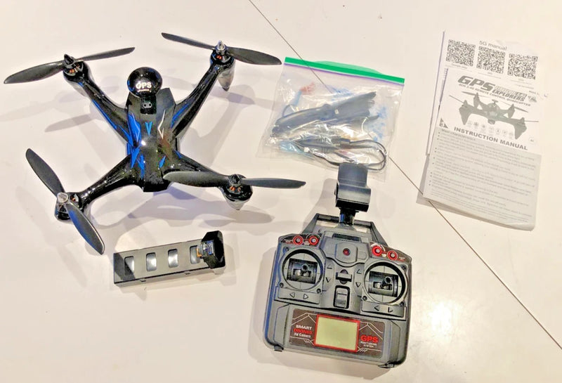 Quadcopter drone with four propellers and blue frame, plus handheld remote controller