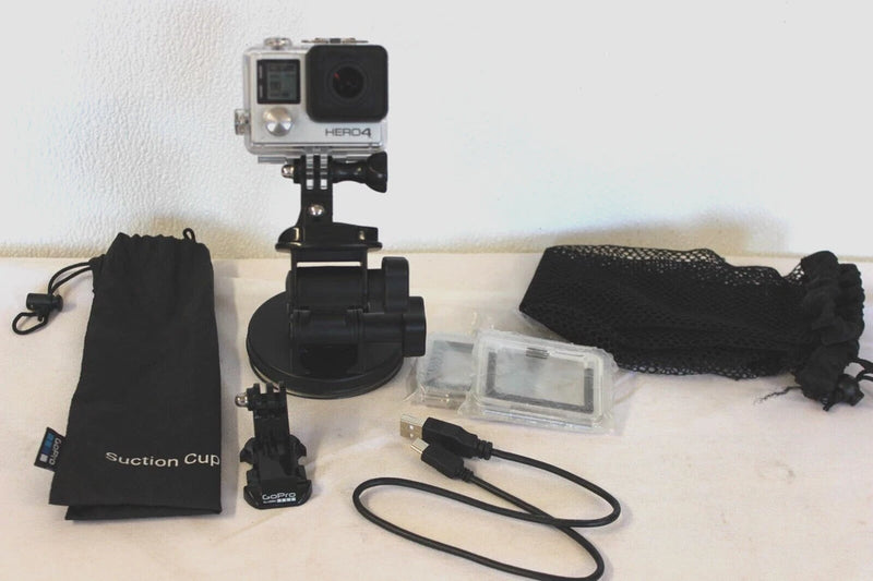 GoPro HERO4 silver action camera with black mount, suction cup, cables, pouch, and case