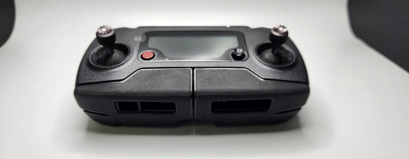 Black remote controller with dual joysticks and built-in display