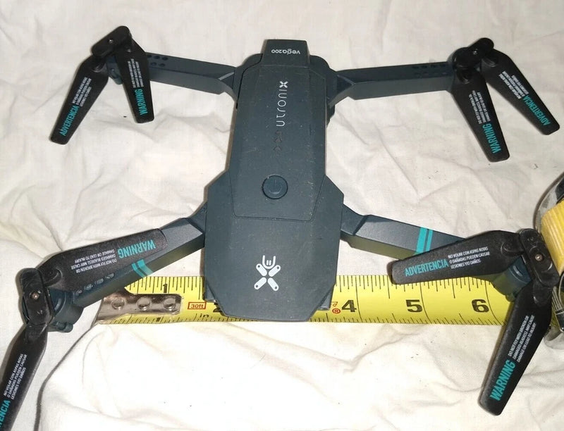 Mini folding drone with four rotors and foldable arms, dark gray body