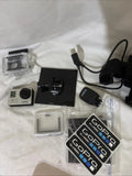 Silver action camcorder kit with HERO 3 camera, waterproof housing, mounts, cables, battery