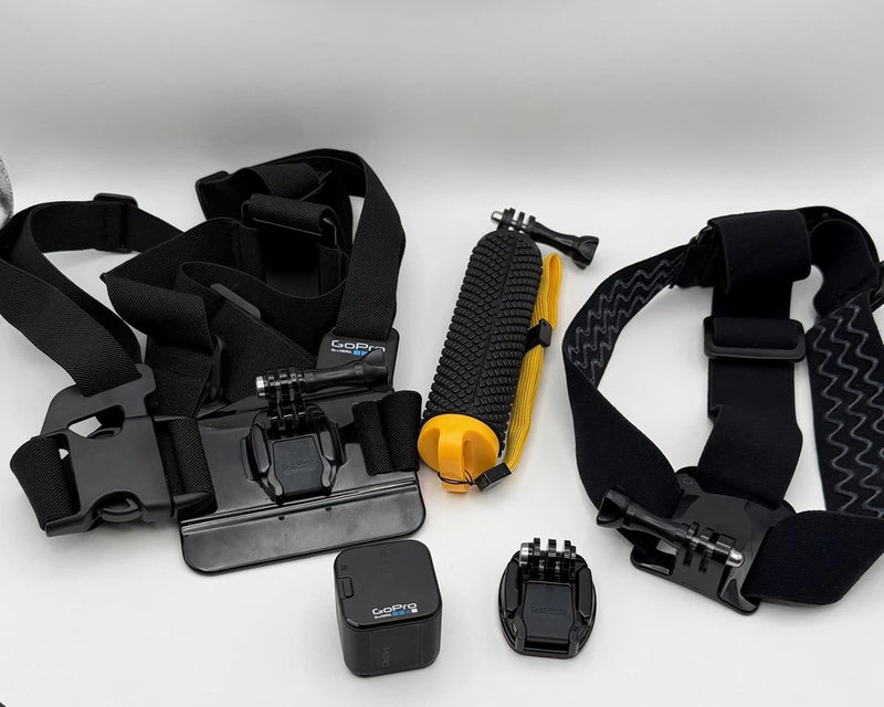 GoPro action camera with protective case, mounting base, and black chest strap harness